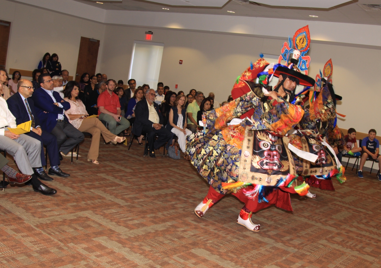 Audience enjoying elaborate costumes and vibrant dance movements, all symbolizing the heritage of the monks.