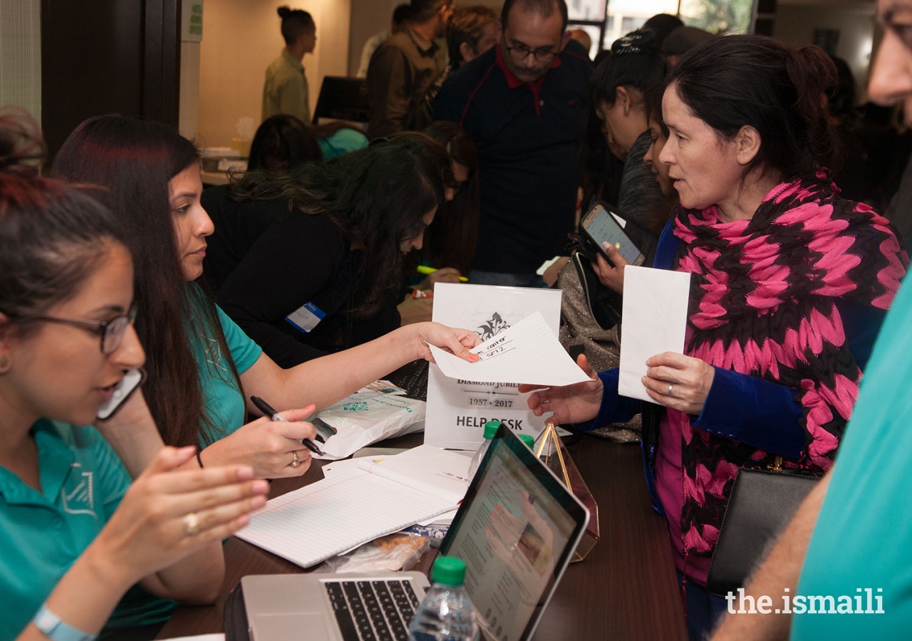 Volunteers provide information to attendees for the Mulaqat events.