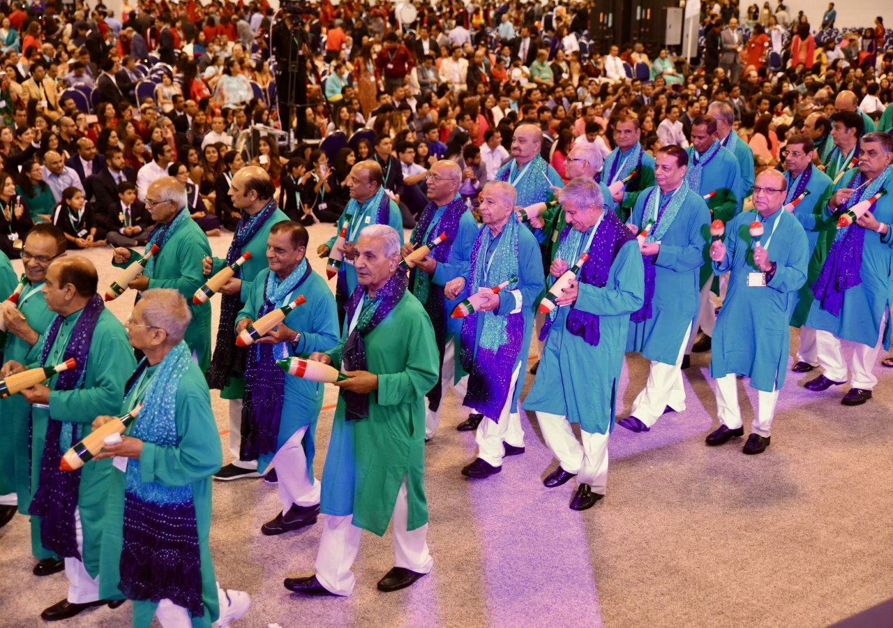 Male members of the Southeast Jamat enter the hall with maracas as their contribution to the One Jamat parade.