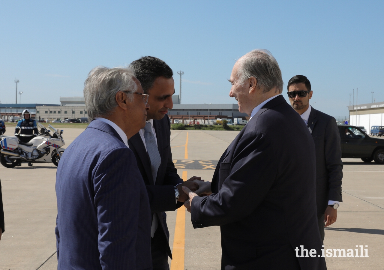 Mawlana Hazar Imam is greeted by Rahim Firozali, President of the Ismaili Council for Portugal, as Nazim Ahmad, Diplomatic Representative of the Ismaili Imamat to the Portuguese Republic looks on.