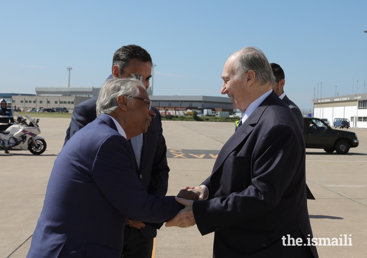 Mawlana Hazar Imam is greeted by Nazim Ahmad, Diplomatic Representative of the Ismaili Imamat to the Portuguese Republic, as Rahim Firozali, President of the Ismaili Council for Portugal looks on.