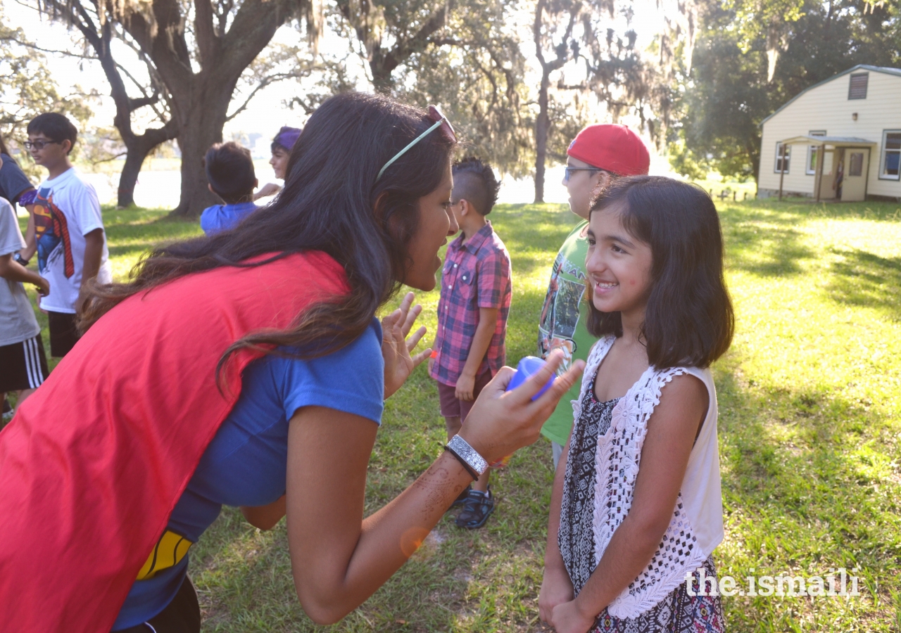 On Superhero day, a counselor engages with her participant one-on-one during sports.