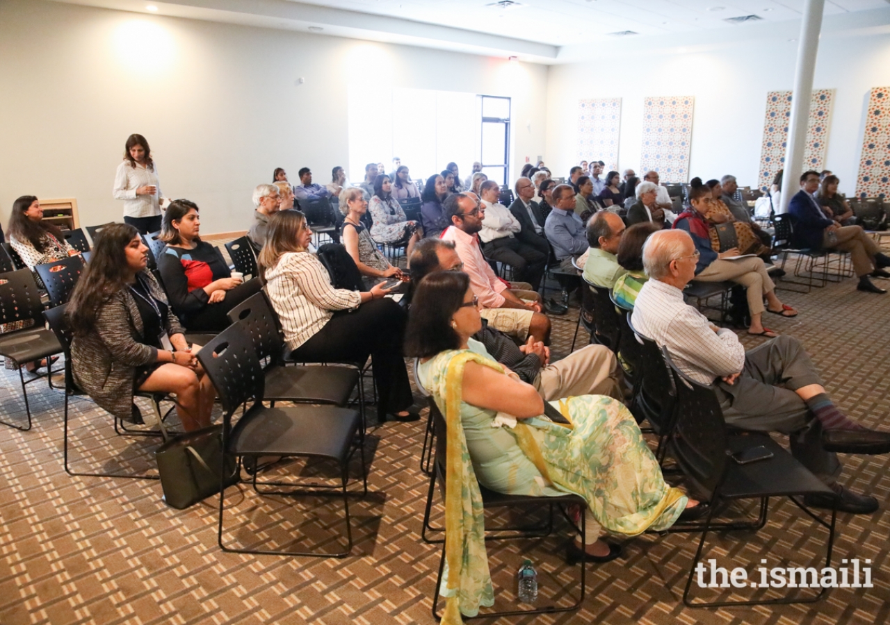 Audience members listen to author John D. Cressler discussing his three-book series, "Anthems of al-Andalus."