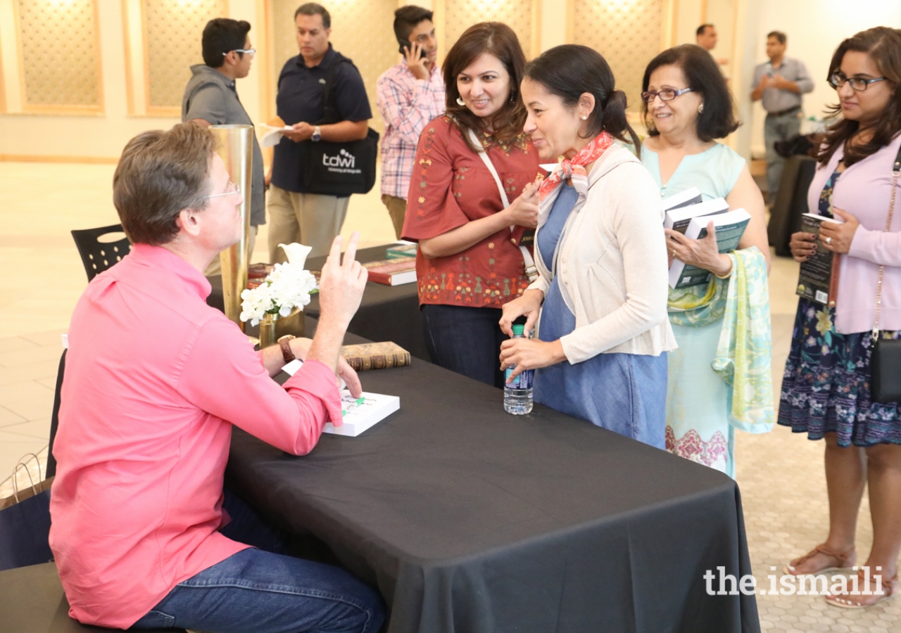 Author John D. Cressler signs "Fortune’s Lament," the third book in the "Anthems of al-Andalus" series, for Jessica Sanchez and Nareen Punjani.