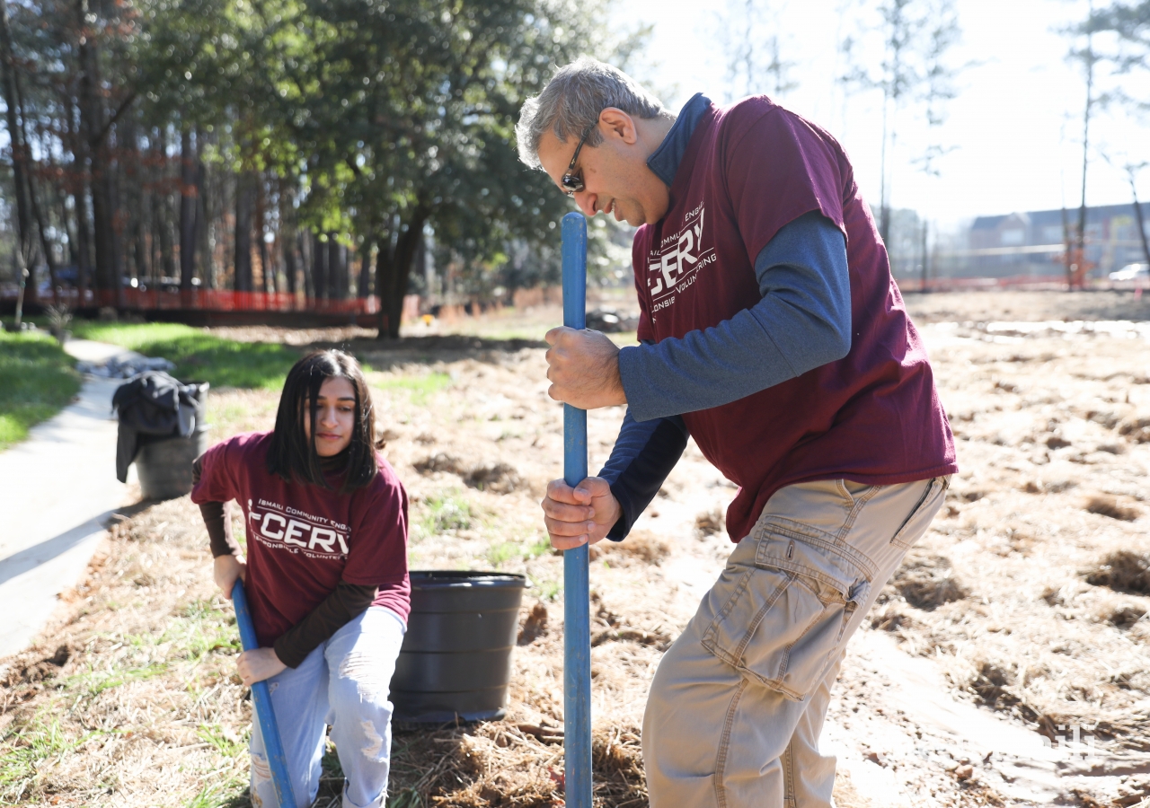 A father and daughter dig a hole for a tree at Brook Run Park in Dunwoody, Georgia.