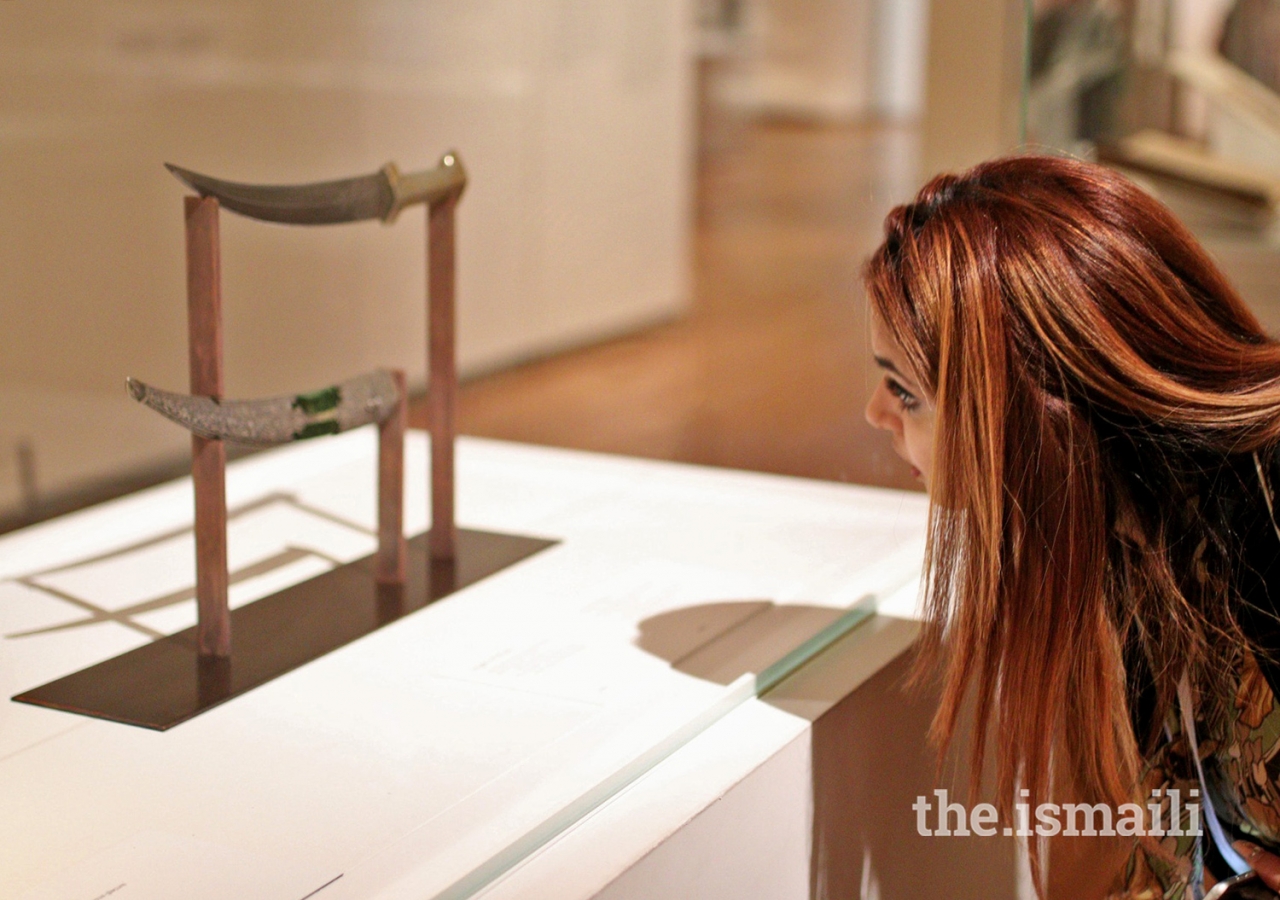 Shehrose Noormohamed, a Jubilee Heritage participant from Chicago, examines an 18th-century dagger and sheath at the Aga Khan Museum.