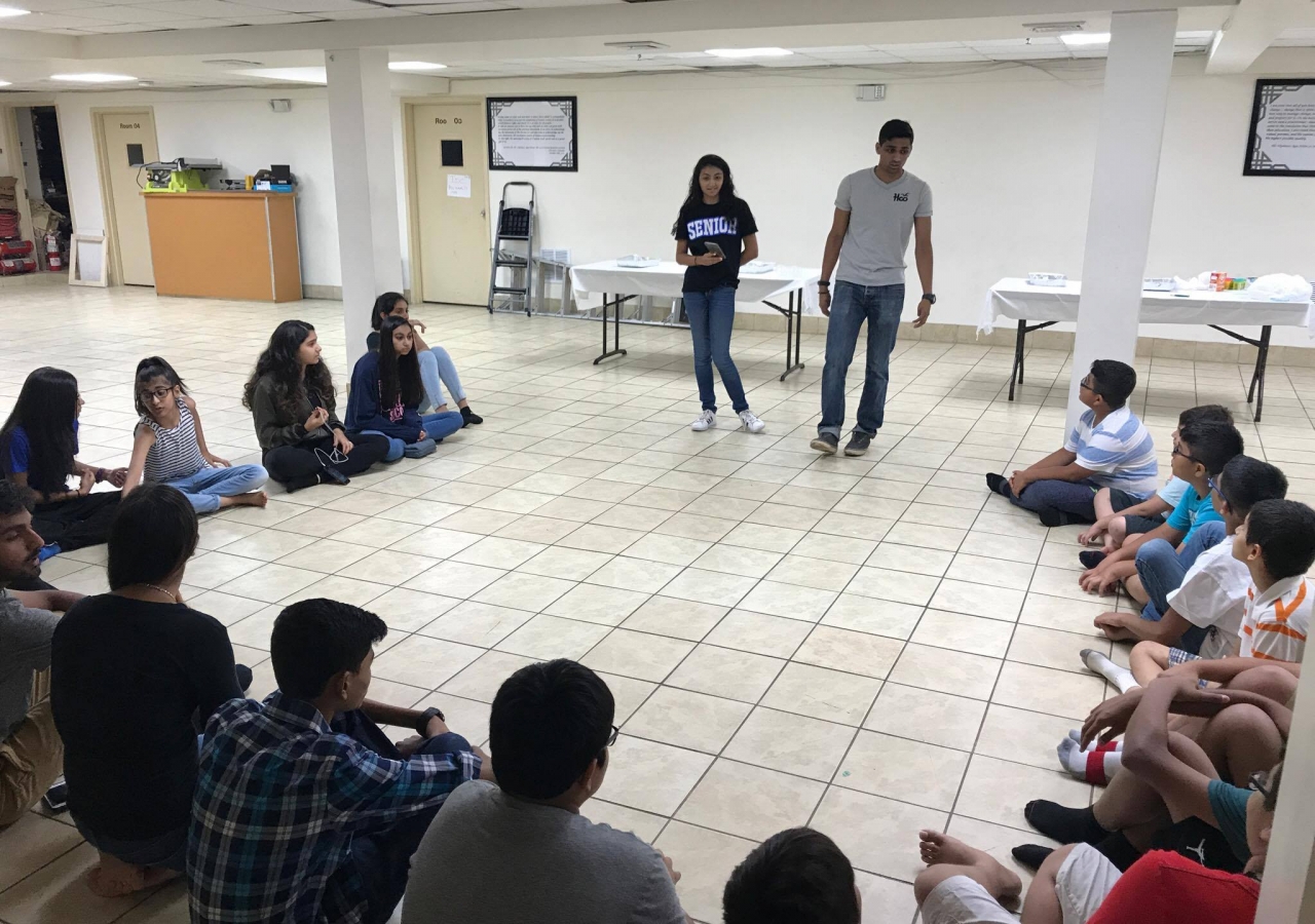 Facilitators Soha Bhimji and Shafeen Hemani discuss renewable energy with participants before building an air propeller car. 