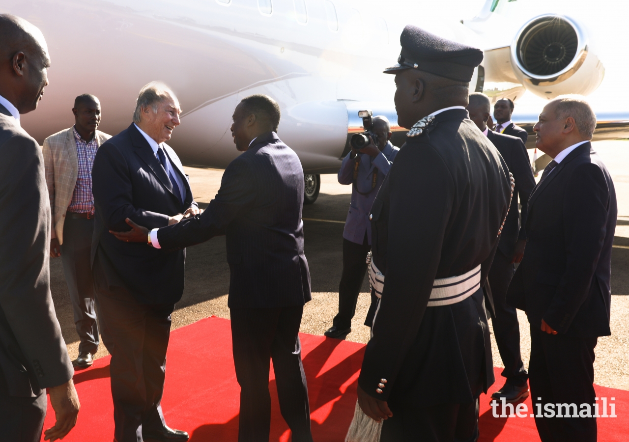 Attorney General Hon. William Byaruhanga greets Mawlana Hazar Imam at Entebbe Airport, as Ismaili Council for Uganda President Minaz Jamal looks on.