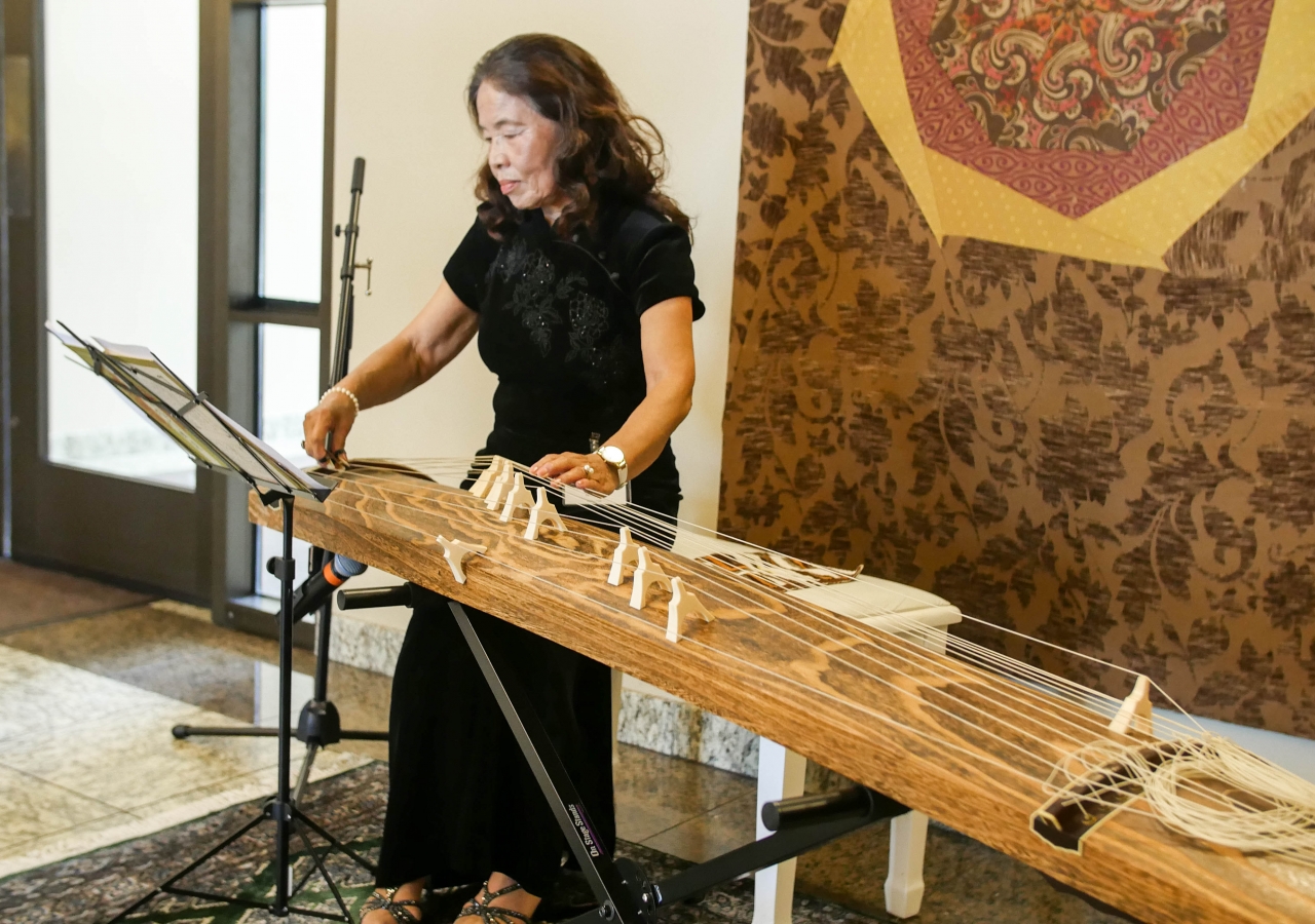 Seema (Chieko) Mithani plays a traditional Japanese instrument called the koto, during the opening reception.