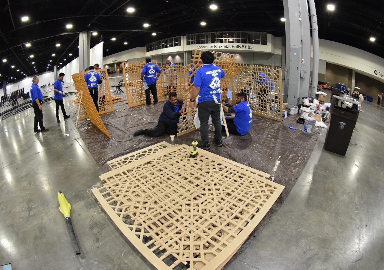 Volunteers from the stage construction team assemble pieces of the mashrabiya panels.