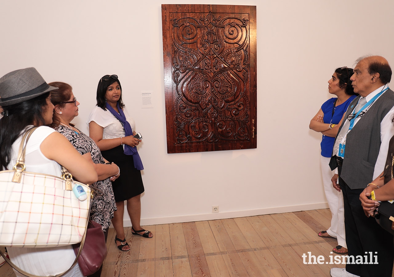 Attendees admire a wood carving on display at the International Art Gallery in Lisbon.