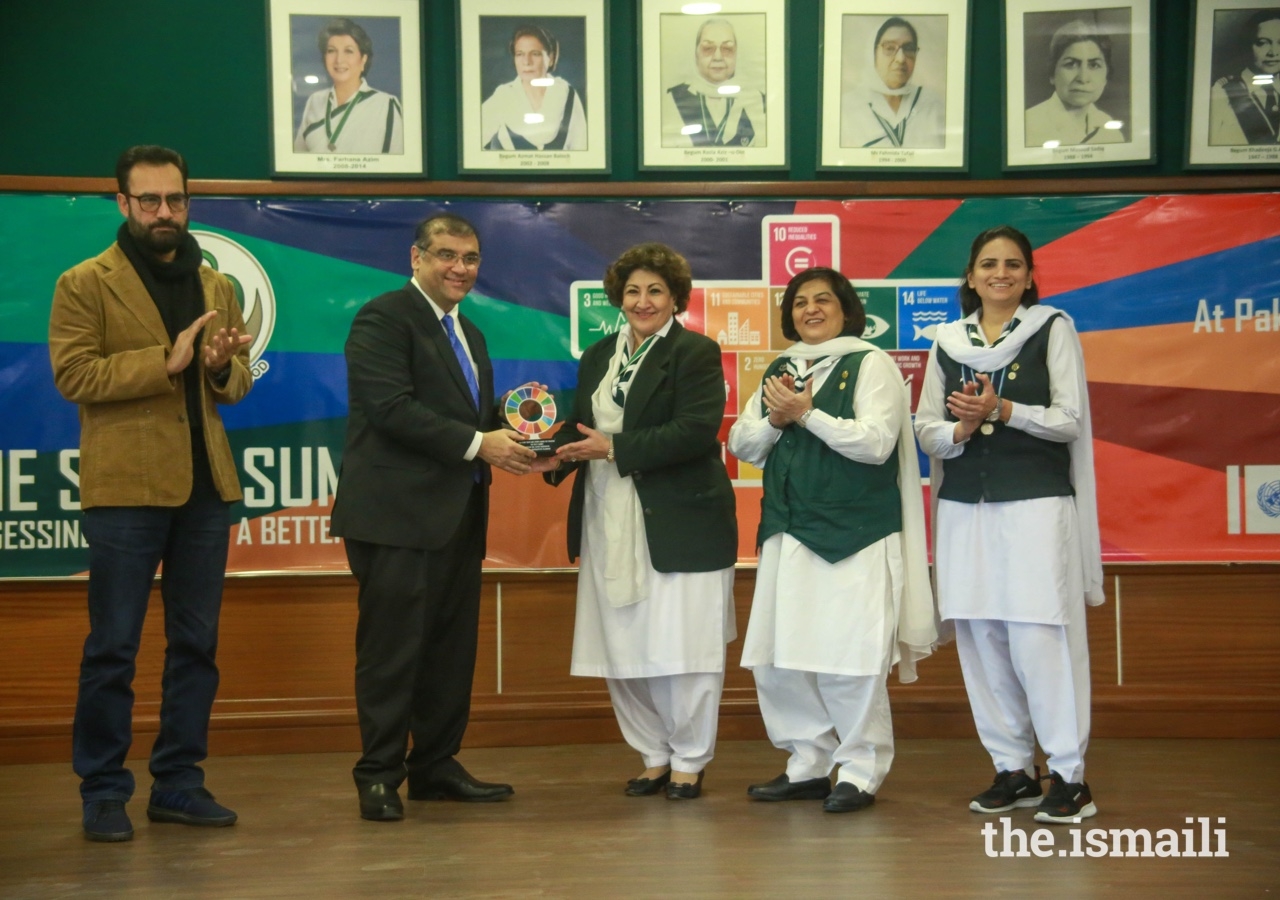 Hafiz Sherali, President of the Ismaili Council for Pakistan presents a token of appreciation to Senator Nuzhat Amir Sadiq, National Commissioner of the Pakistan Girl Guides Association.