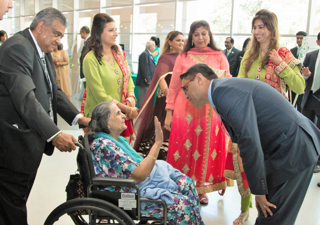 Mukhi Saheb Minhaz Lakhani wishes an elderly Jamati member. Leadership formed an honor guard to welcome the Jamat to the Diamond Jubilee Opening Ceremonies.