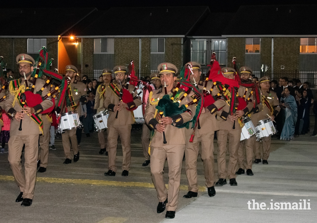 The Al-Azher Pipe Band leads the procession for the IVC100 pinning ceremony at Beaumont Jamatkhana.