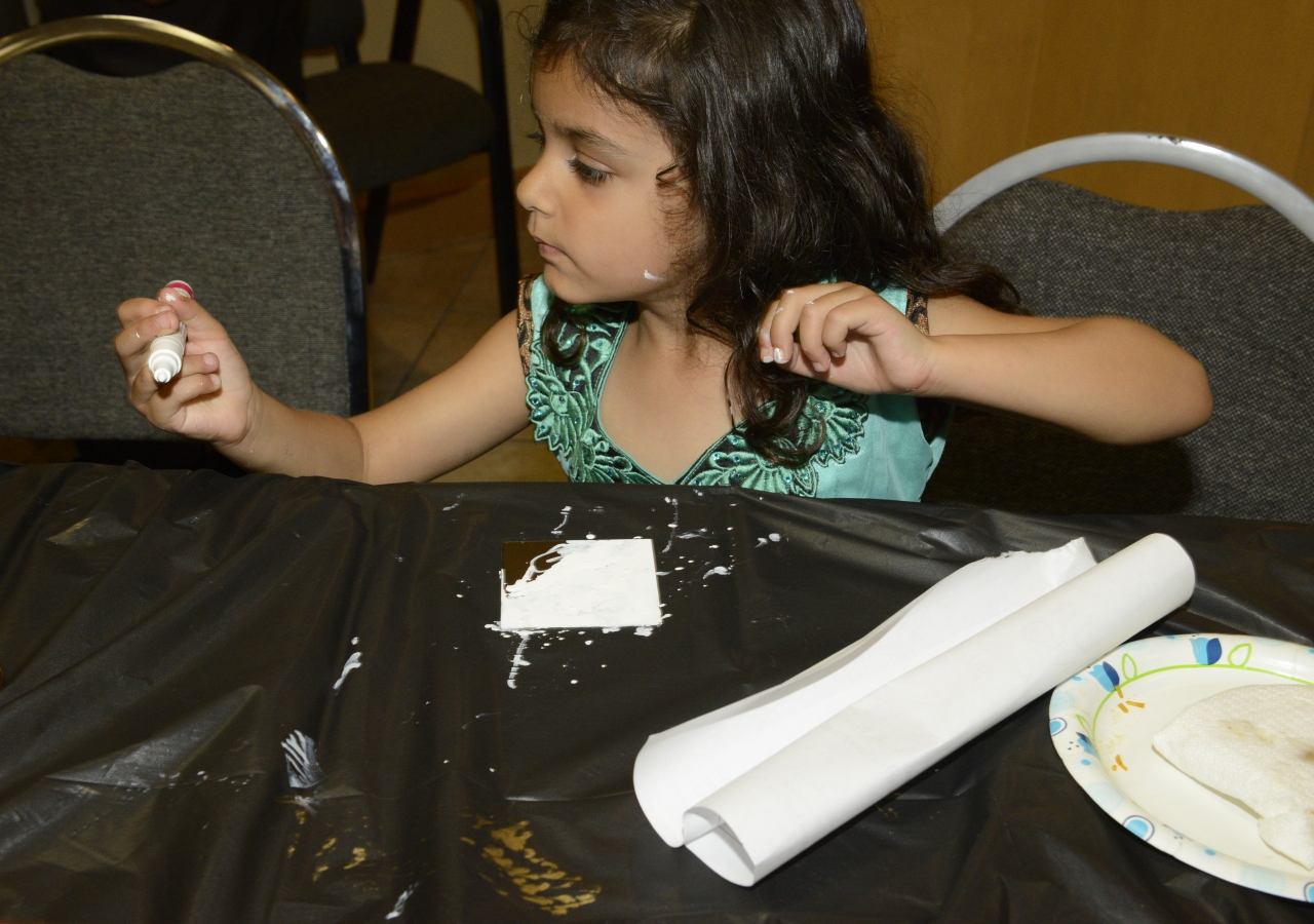 A child painting a tile