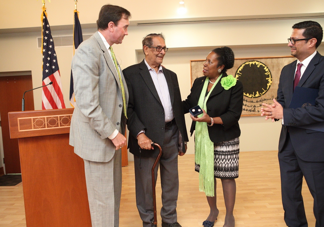 US Congressman Pete Olson (R), left, and US Congresswoman Sheila Jackson Lee (D), present Mr. Sadruddin Mangalji, the oldest person in the audience, with a pair of US House of Representatives cufflinks.