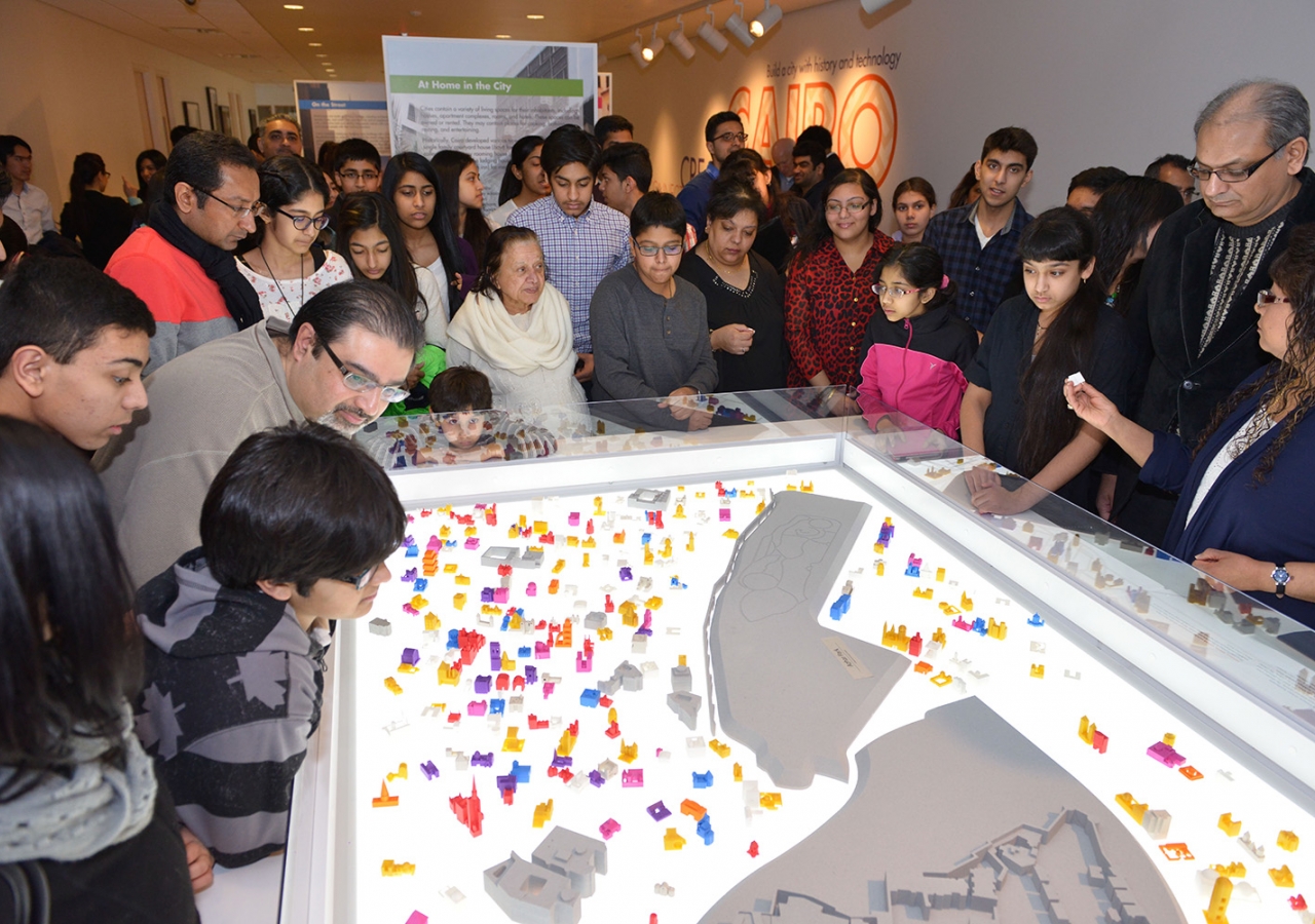 Visitors gather around the architectural-scale model of a historic district of Cairo that served as a centrepiece of the exhibition and was populated by houses designed and printed by 3D workshop participants. Vazir Karsan