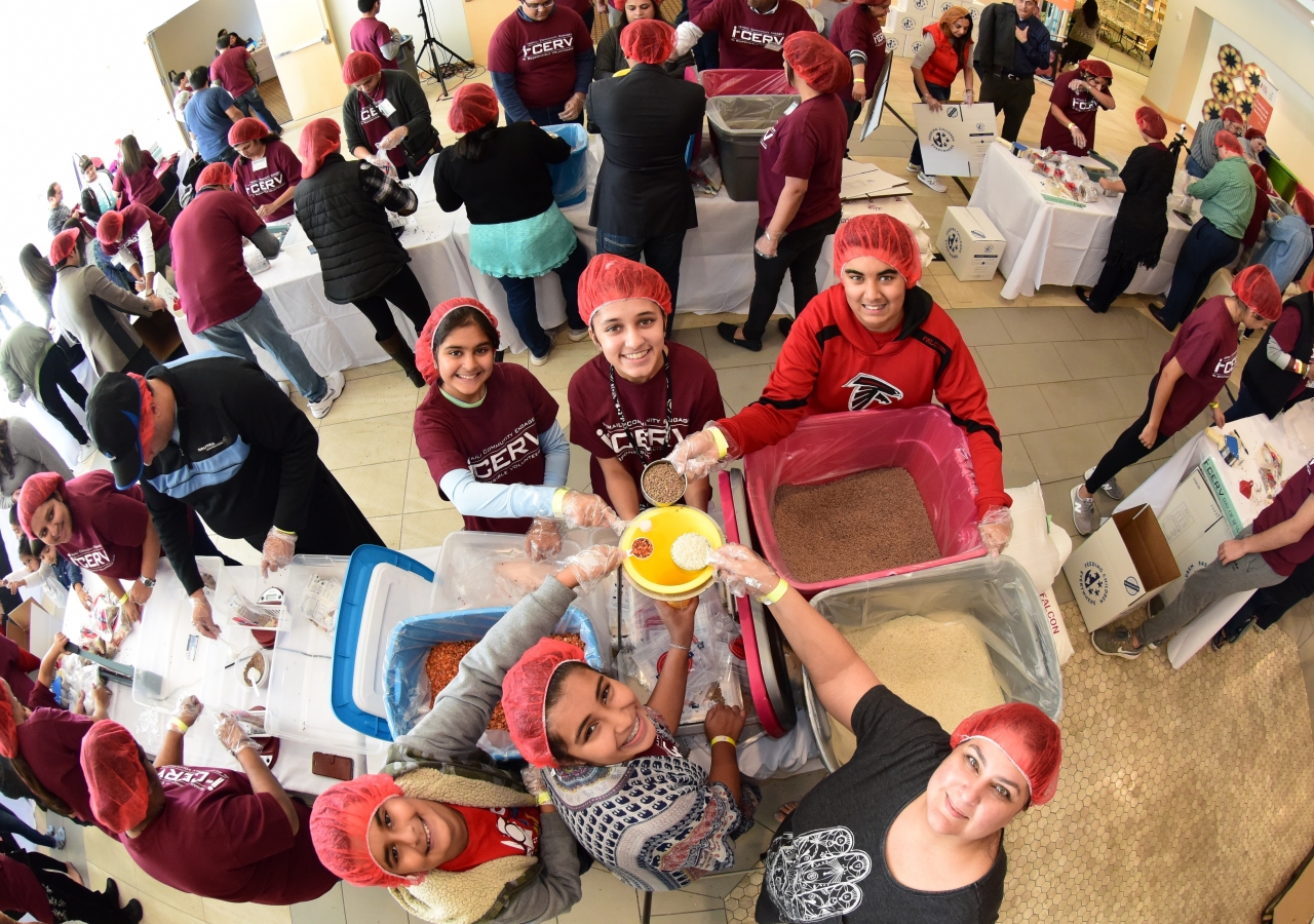 Volunteers display teamwork as they measure rice, lentils, dehydrated vegetables and Himalayan salt for meals donated to Atlantans in need.