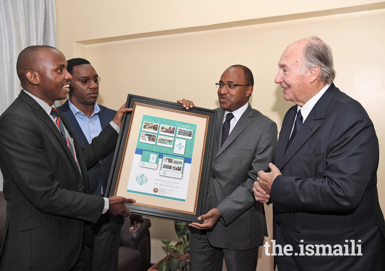 Mawlana Hazar Imam is presented with a gift of First Day Covers and Commemorative Stamps created by the Tanzania Postal Service Corporation in honour of his Diamond Jubilee.