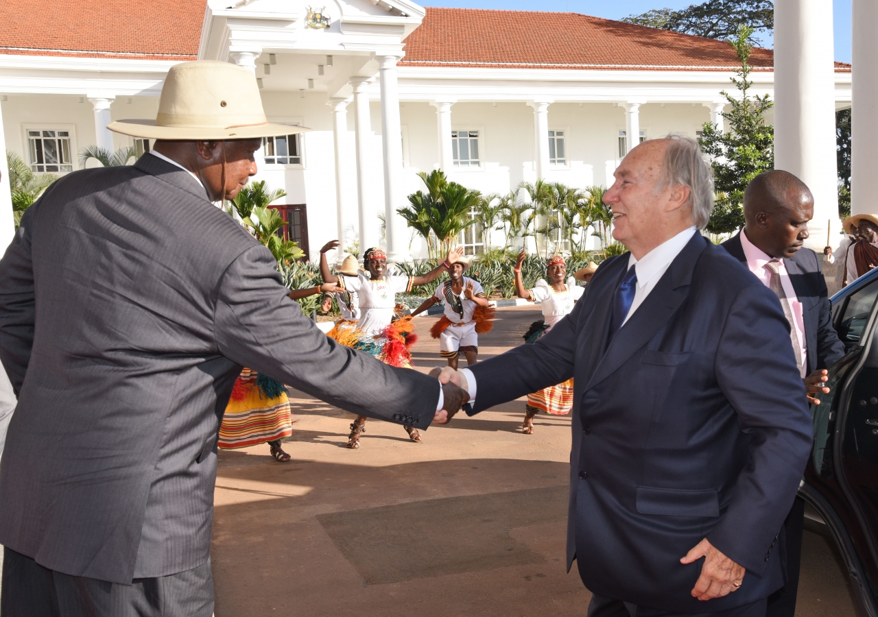 His Excellency President Yoweri Kaguta Museveni welcomes Mawlana Hazar Imam to the State House in Entebbe as traditional Ngoma dancers perform in the background.