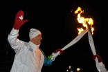 In a kiss of torches, Salim Ahmed receives the Olympic flame in Abbotsford, British Columbia.