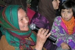 At the Kabul International Women’s Day event organised by the Ismaili Council for Afghanistan, an audience member asks a question, as a young girl looks on.