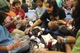 A counselor helps participants tie-die shirts during a self-expression activity at an Ismaili summer camp.