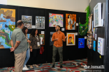 A visual artist explains his art to Jamati members at the Southwest United States Ismaili Arts Festival Art Gallery.