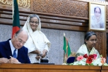 Mawlana Hazar Imam signs a protocol agreement with Foreign Minister Dr Dipu Moni between AKDN and the Government of Bangladesh, as Prime Minister Sheikh Hasina looks on.