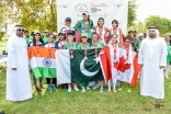 Medalists in women&#039;s track &amp; field gather for a photo behind their respective flags on the final day of competition. JG / Akber Dewji