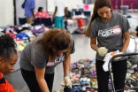 I-CERV volunteers organizing and bagging donated clothing items at the George R. Brown Convention Center. 