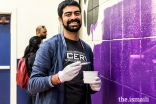 Samir Lakhani assists with painting a mural in the school gymnasium.