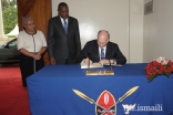 Mawlana Hazar Imam signs the guest book at the State House in Nairobi as His Excellency President Uhuru Kenyatta and First Lady Margaret Kenyatta look on.