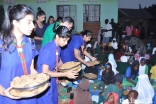 Young members of the Aga Khan Scouts and Guides in Uganda serve meals to orphaned children at the Kasanagati Orphan Fans Society in Kawanda.