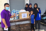 A volunteer delivers a care package to a family as part of the partnership programme between Ismaili CIVIC and Yayasan Chow Kit in Malaysia.