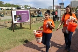 I-CERV volunteers carry orange buckets collecting funds in support of the Richmond Folk Festival.