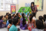 Children listen attentively to Sonia Mackwani during a storytelling session.