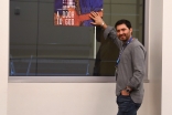 Maruf Noyoft next to a poster of his film, "A Door to God."