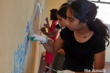 Students, and volunteer artists paint the walls of the refectory of the Magnificat Centre.