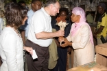 The Aga Khan is presented with a bouquet of dried flowers by Balbina Pinheiro. In the back, the Minister of Courtesy (Minister of Tourism), Mr Fernando Sumbana and the Director of the Entrepeneur Development Initiave, Eliane Damasceno looks on, 23 November 2007.