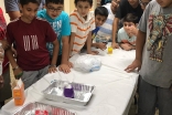 Participants observe as they begin to experiment with chemical reactions in their model volcanoes. 