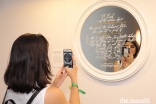 An International Art Gallery attendee snaps a photo of one of the pieces of art on display.