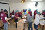 A room full of volunteers help pack food in Milwaukee Jamatkhana.