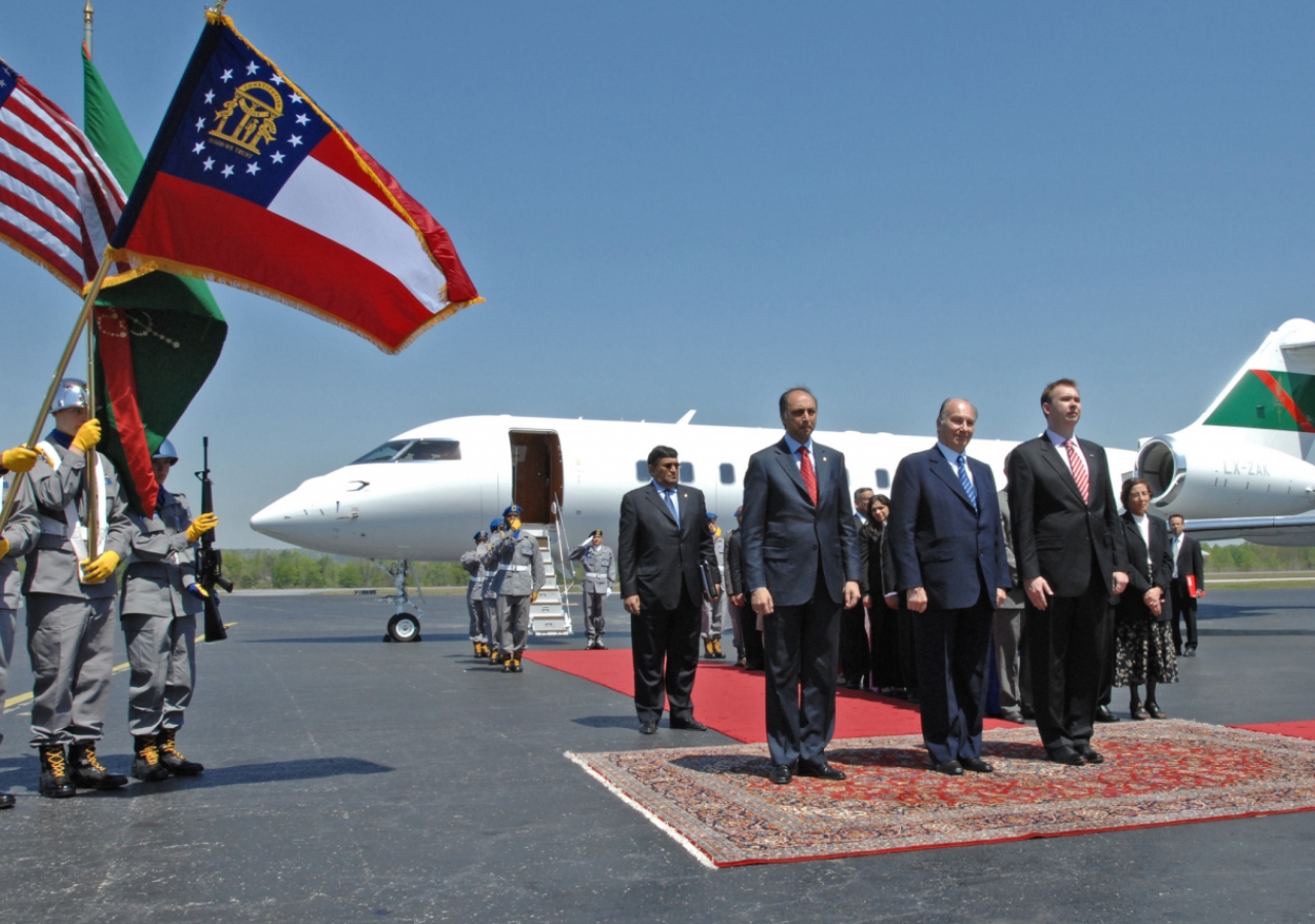 Mawlana Hazar Imam with President Mahmoud Eboo of the Ismaili Council for USA and Chris Young, Chief of Protocol for the State of Georgia, listening to the Honor Cordon Band from the Youth Challenge Academy as they perform the US National Anthem and the N