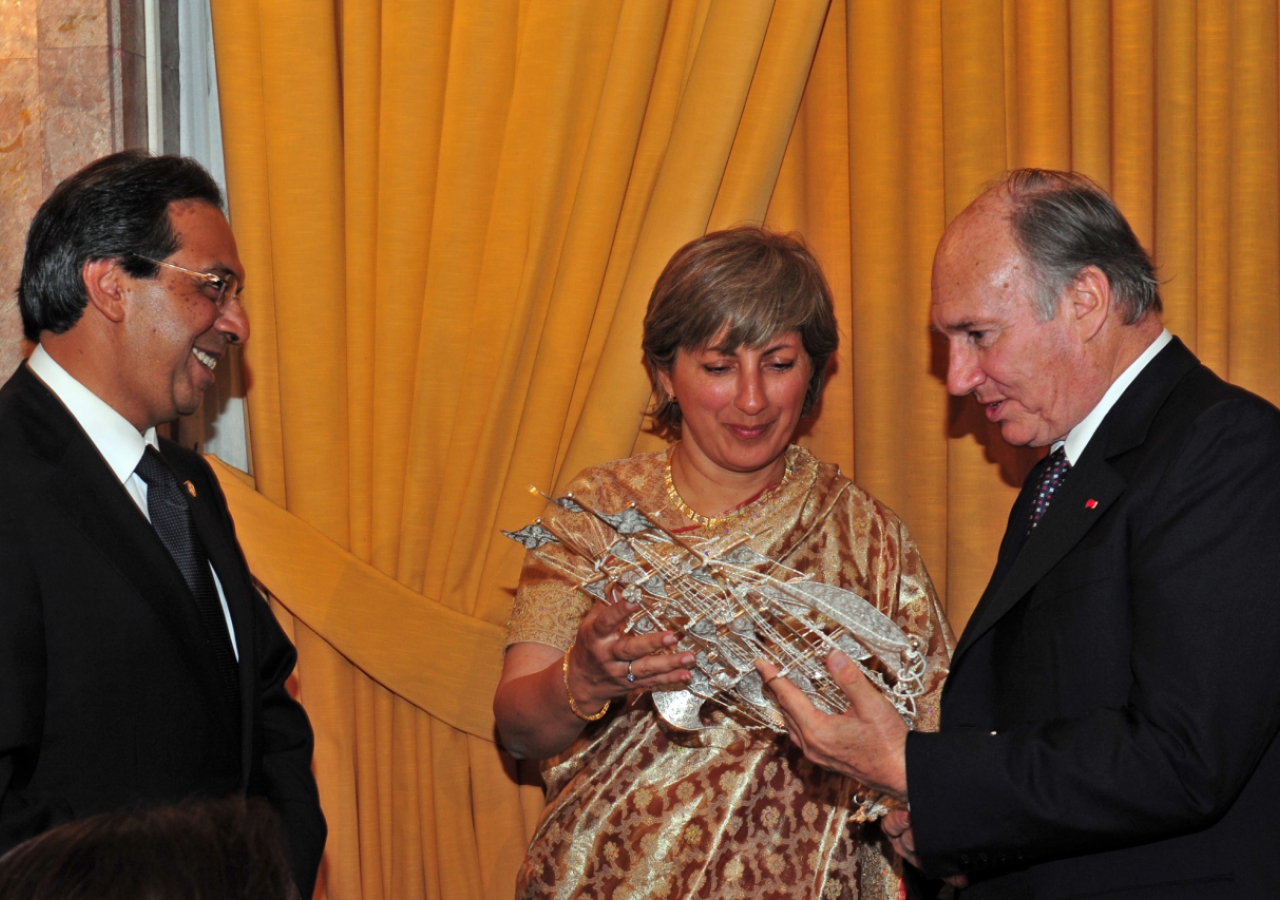 Chairman of ITREB Portugal, Parveeza Sacoor, presents a gift to Mawlana Hazar Imam as President Amirali Bhanji looks on. 