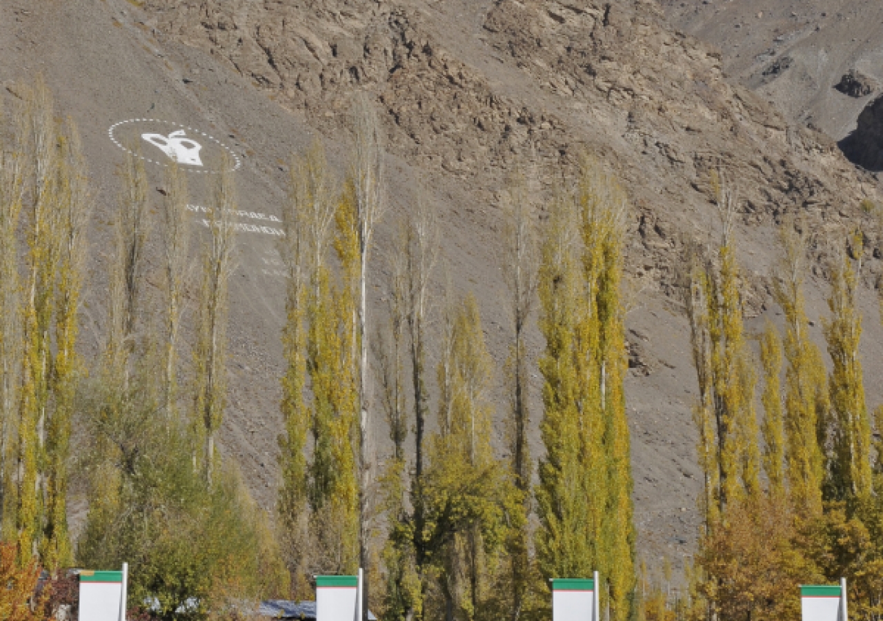 A mountain-side sign commemorating Mawlana Hazar Imam’s Golden Jubilee visit overlooks the site of the new Ismaili Jamatkhana and Centre in Khorog, where members of the Jamat have gathered to witness the foundation laying ceremony.   