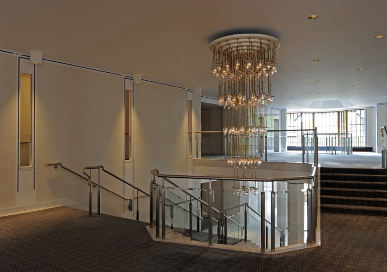 The main stairway pivots about an impressive chandelier.