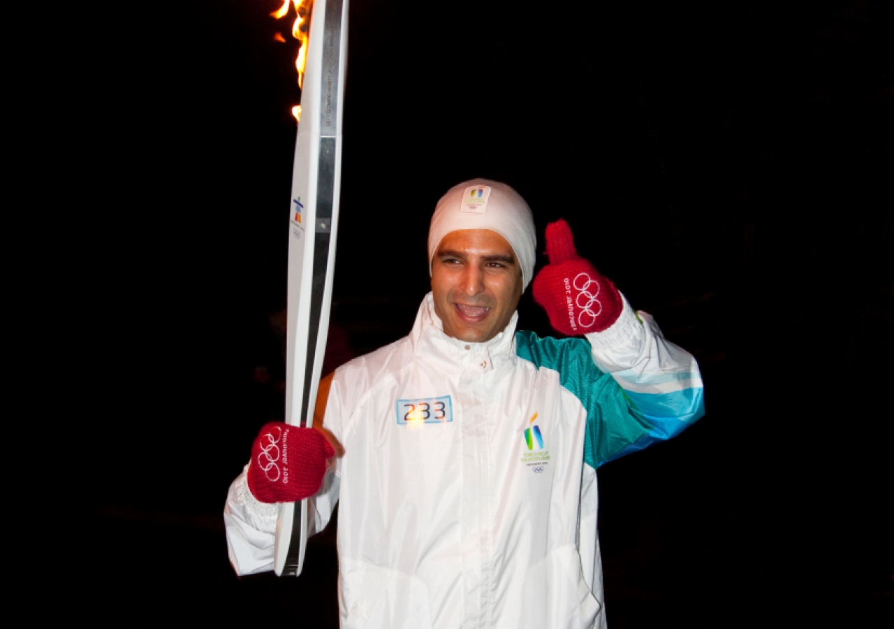 Sohail Shariff acknowledges the crowd as he carries the Olympic torch.