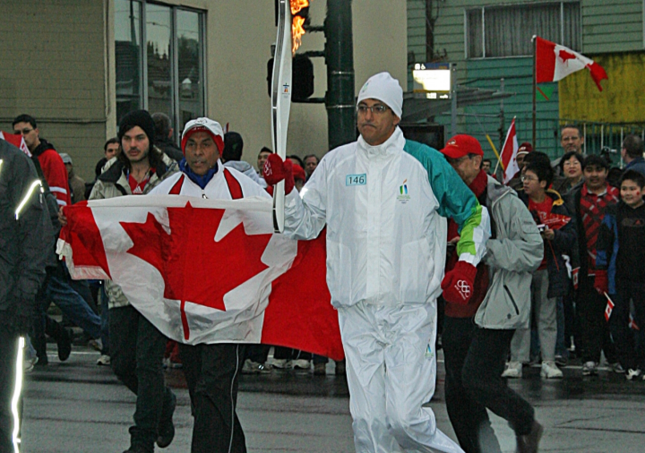 Ismaili Council for Canada Vice-President Malik Talib carries the Olympic flame in Vancouver.