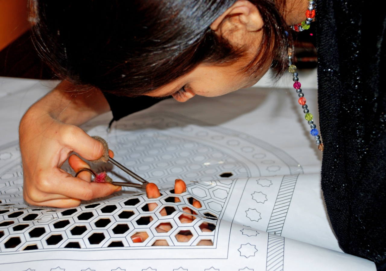 A young girl from Nizamuddin Basti cuts sanjhi patterns. Raising awareness among residents about the rich cultural heritage of the neighbourhood they live in is part of the conservation effort.